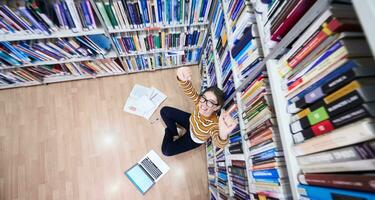 der Schüler benutzt ein Notizbuch und eine Schulbibliothek foto