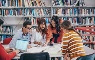 studentengruppe, die gemeinsam an einem schulprojekt auf einem tablet-computer an einer modernen universität arbeitet foto