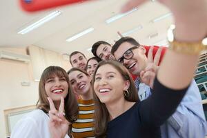 Gruppe multiethnischer Teenager, die in der Schule ein Selfie machen foto