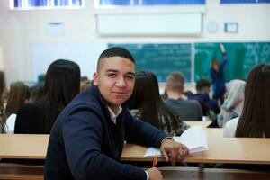 Student, der sich während des Studiums in der High School Notizen macht foto