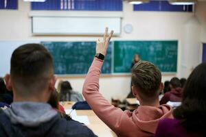 Der Student hebt die Hände und stellt im College eine Frage foto