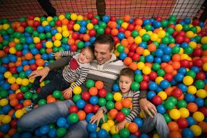 jung Papa mit Kinder im ein Kinder- Spielzimmer foto