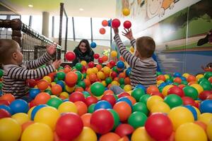 junge Mutter mit ihren Kindern in einem Kinderspielzimmer foto