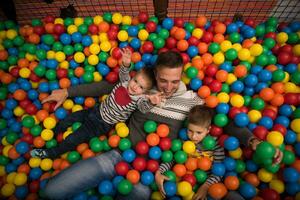 jung Papa mit Kinder im ein Kinder- Spielzimmer foto