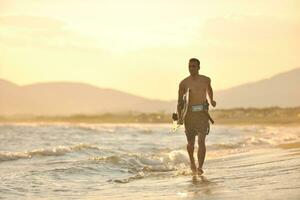 Porträt eines jungen Kitsurf-Mannes am Strand bei Sonnenuntergang foto