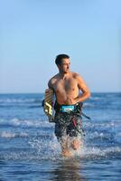 Porträt eines jungen Kitsurf-Mannes am Strand bei Sonnenuntergang foto