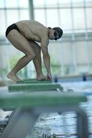 junger Schwimmer startbereit foto