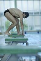 junger Schwimmer startbereit foto