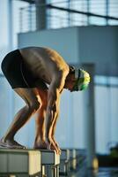 junger Schwimmer beim Schwimmstart foto