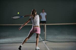 junge Mädchen, die Indoor-Tennisspiel spielen foto