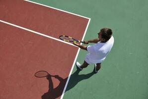 junger Mann spielt Tennis im Freien foto