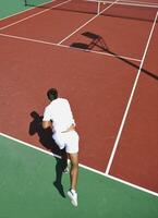 junger Mann spielt Tennis im Freien foto