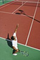 junger Mann spielt Tennis im Freien foto