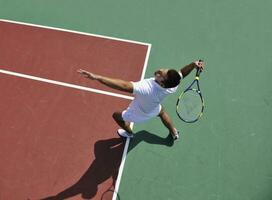 junger Mann spielt Tennis im Freien foto