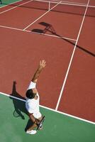 junger Mann spielt Tennis im Freien foto