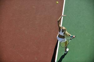 junge Frau spielt Tennis im Freien foto