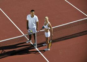 glückliches junges paar spielt tennisspiel im freien foto