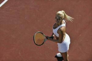 junge Frau spielt Tennis im Freien foto