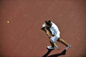 junger mann spielt tennis foto