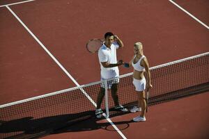 glückliches junges paar spielt tennisspiel im freien foto