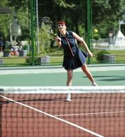 junge frau spielt tennisspiel im freien foto