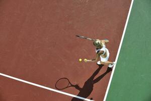 junge Frau spielt Tennis im Freien foto