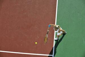 junge Frau spielt Tennis im Freien foto