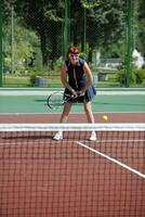 junge frau spielt tennisspiel im freien foto