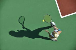 junge Frau spielt Tennis im Freien foto