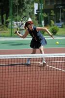 junge frau spielt tennisspiel im freien foto