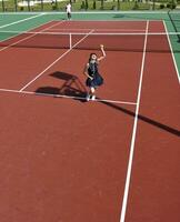 junge frau spielt tennisspiel im freien foto