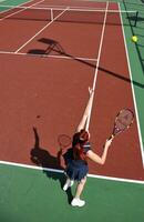 junge frau spielt tennisspiel im freien foto