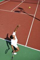 junger Mann spielt Tennis im Freien foto