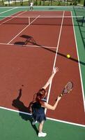 junge frau spielt tennisspiel im freien foto