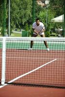 junger Mann spielt Tennis im Freien foto