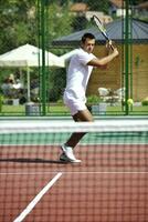 junger Mann spielt Tennis im Freien foto