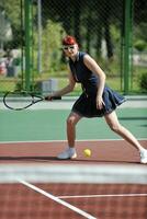 junge frau spielt tennisspiel im freien foto