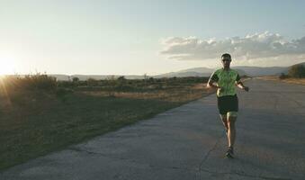 triathlonsportler, der beim morgendlichen training läuft foto