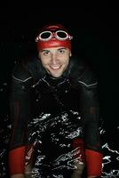 authentischer triathlet-schwimmer, der nachts während des harten trainings eine pause macht foto