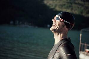 Triathlonsportler beginnt mit dem Schwimmtraining auf dem See foto