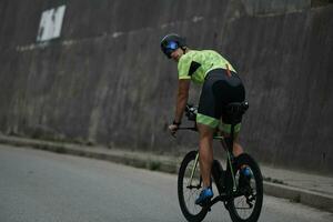 triathlonsportler, der beim morgendlichen training fahrrad fährt foto