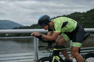 triathlonsportler, der beim morgendlichen training fahrrad fährt foto