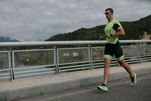 Triathlonsportler, der auf der Straße läuft foto