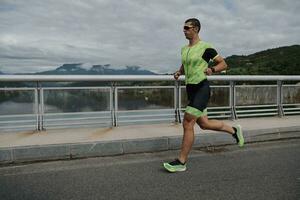 Triathlonsportler, der auf der Straße läuft foto