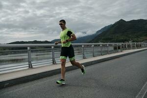 Triathlonsportler, der auf der Straße läuft foto