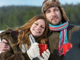 glückliches junges Paar trinkt im Winter warmen Tee foto