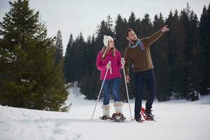 paar, das spaß hat und in schneeschuhen geht foto