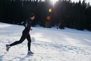 Joggen auf Schnee im Wald foto