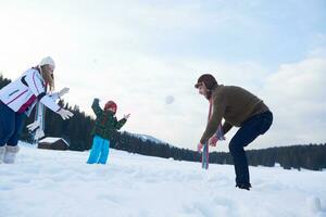 glückliche Familie, die im Winter zusammen im Schnee spielt foto