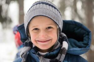 kleiner junge, der spaß am wintertag hat foto